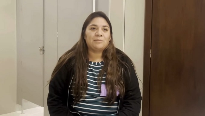fotografía de una enfermera joven, de pelo castaño y largo, con remera rayada y campera negra.